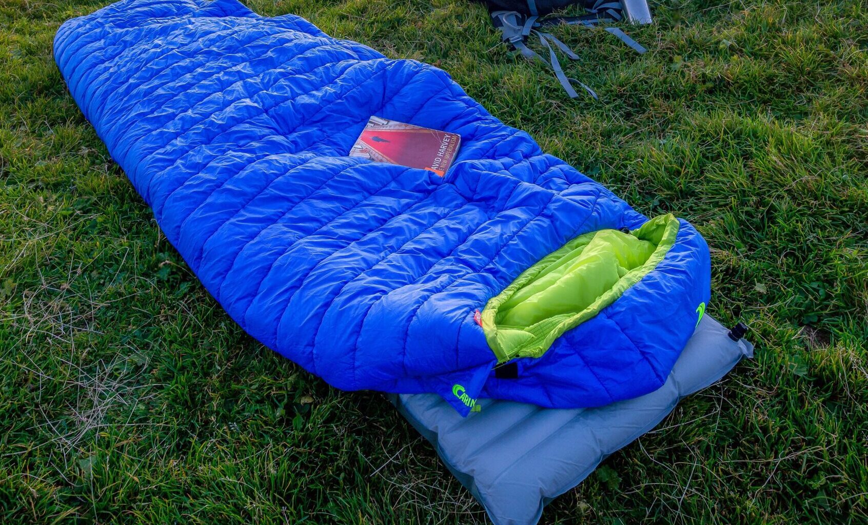 hiking sleeping bag lay on grass with a great mountain view